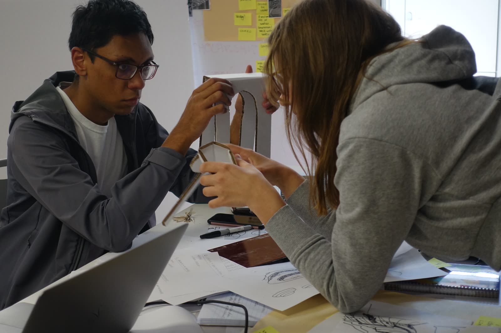 Jugraj and a teammate examining a design prototype
