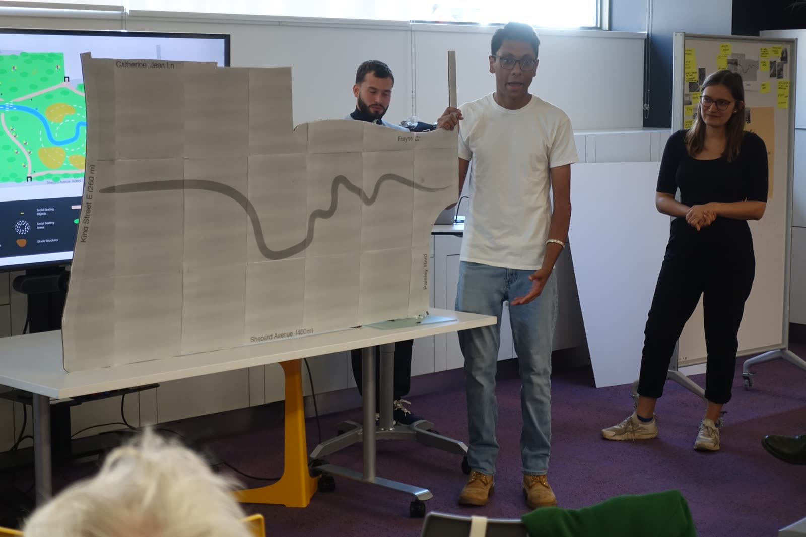 Jugraj presenting a hand-drawn plan for Cooksville Park to an audience