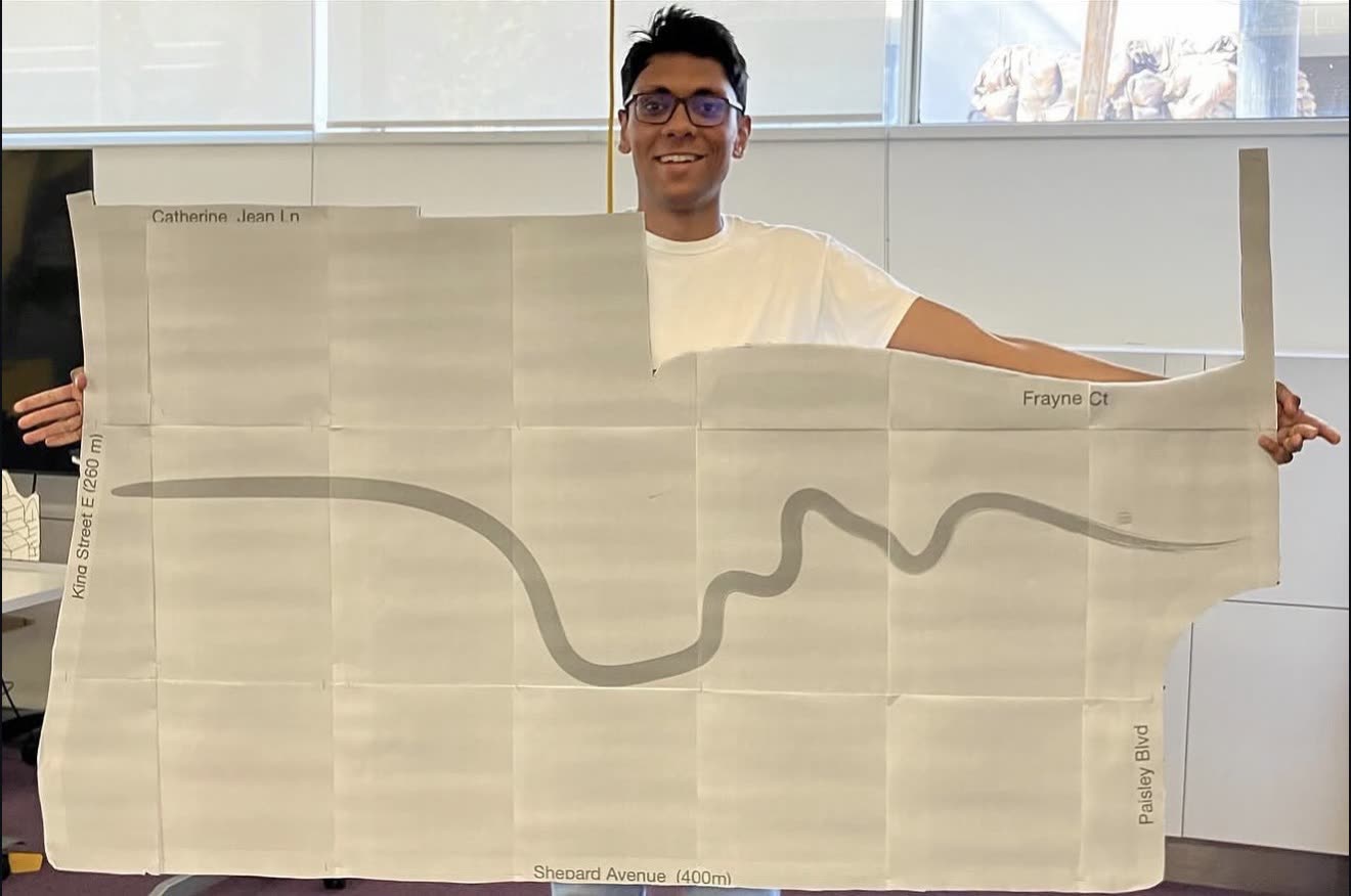 Jugraj holding up the large hand-drawn Cooksville Park plan
